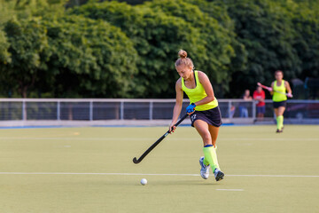 Young field hockey female player in attack