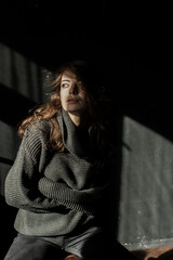 Sensual portrait of beautiful woman in sun light. Dark background 