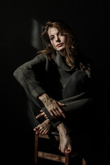 Sensual portrait of beautiful woman in sun light. Dark background 