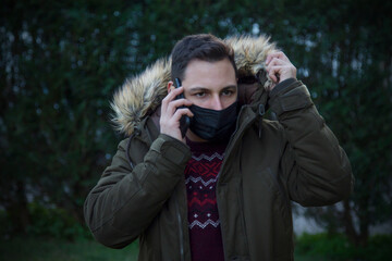 man with medical mask as protection from viruses and infections talking to the smart phone