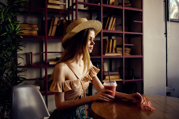 Beautiful woman sits at a table in a cafe glass of juice relaxation more fun