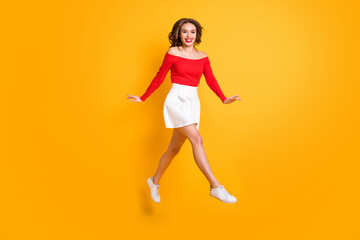 Fototapeta na wymiar Full length body size photo girl wearing fashion clothes smiling jumping stepping forward isolated on vivid yellow color background