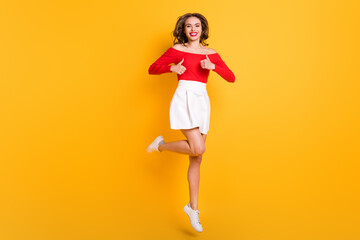 Full length body size photo girl wearing stylish outfit laughing showing like gesture both hands isolated on vibrant yellow color background