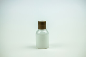 A picture of a little white bottle of shampoo in back a white background