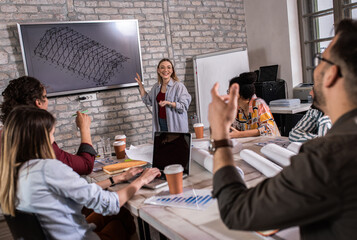 Group of young people discussing architectural designs in the creative office.	