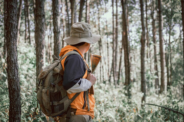 Obraz premium Male holding map for check location adventure in forest, Holidays concept