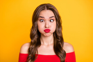 Photo portrait of pretty model grimacing fooling keeping air in cheeks isolated on vivid yellow...