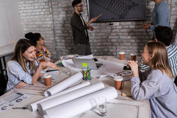 Group of young people discussing architectural designs in the creative office.	