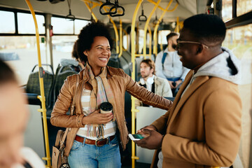 Happy African American couple talking while commuting by bus.
