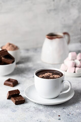 Hot chocolate cocoa cup with  chocolate slices  and marshmallow on concrete  and background.