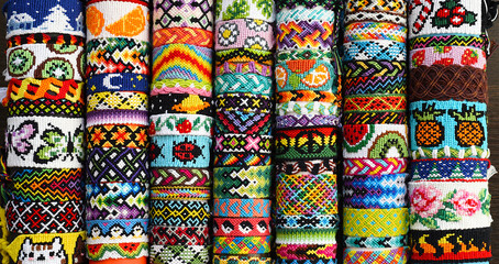 Many tied woven DIY friendship bracelets handmade of embroidery floss. Alpha and normal patterns