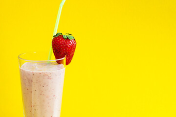 Milk strawberry smoothie made from fresh fruits on a bright background. Strawberry cocktail. A glass of delicious milk cocktail with strawberries. Copy space.