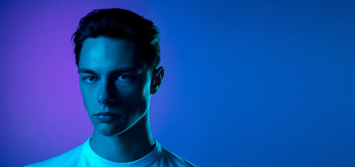 Night. Handsome caucasian man's portrait isolated on purple studio background in neon, monochrome....