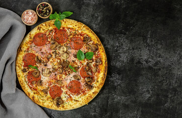 Fresh italian pizza with mushrooms, ham, tomatoes, cheese on on black background.