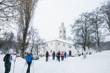 Group of hikers et orthodox monastery Velika Remeta on the mountain Fruška Gora in northern Serbia. Winter snowy day.