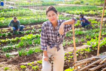 Portrait of kazah woman with gardening tools outdoors. Asian woman standing with shovel in her vegetables garden