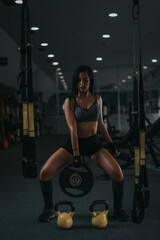 Fototapeta na wymiar Young female in gym. Young woman in gym working out. Girl in gym training hard.