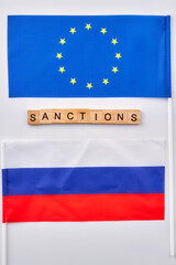 Flags of Russian and European Union. Word sanctions made of wooden cubes.