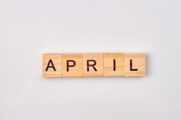 April word written on wood blocks. Isolated on white background.