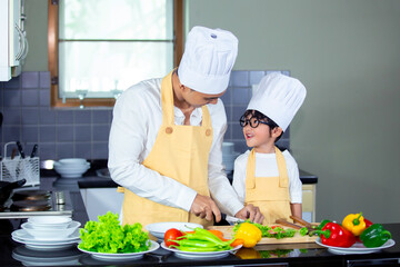 Happy family Asian man young father with son boy cooking healthy salad for the first time. first lesson and healthy lifestyle concept.