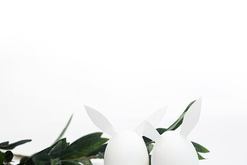 Minimalistic Easter concept on a white background. White Easter eggs with bunny ears