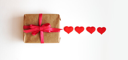 Background to Valentine's Day. Gift box on a wooden background and decorative hearts.