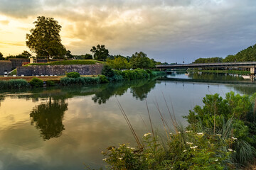 Fototapeta premium Green landscape with reflections on the Bayonne River in France. 