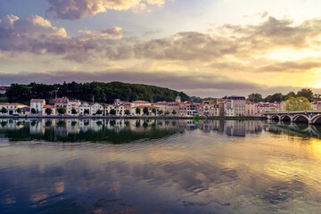 City of Bayonne in France at night with houses of typical architecture and reflections on the Adur River
