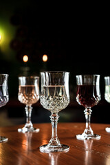 Different kinds of drinks in vintage cocktail glasses in a bar