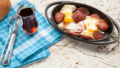 Fried eggs with sausage in pan