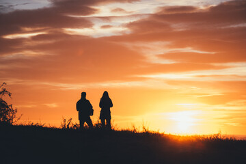 Fototapeta na wymiar Silueta de pareja delante del mar mirando al sol durante el atardecer
