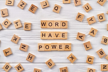 Phrase words have power on wood floor. Blocks of alphabet letters on background.