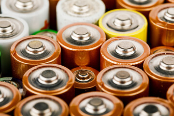 Isolated old battery leakage, hazardous waste concept. Energy abstract background of colorful batteries.