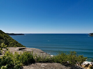 Fototapeta na wymiar Beautiful view of a deep blue sea with white sandy beach, small island and deep blue sky in the background, Mount Ettalong Lookout, Pearl Beach, Brisbane Water National Park, New South Wales, Australi