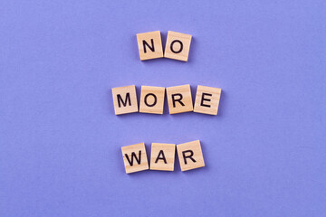 Stop the war concept. Idea of humanity and peace. Wooden cubes with letters isolated on blue background.