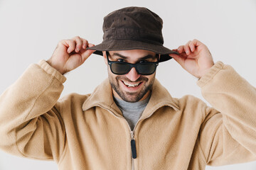 Joyful handsome guy in sunglasses smiling and looking at camera