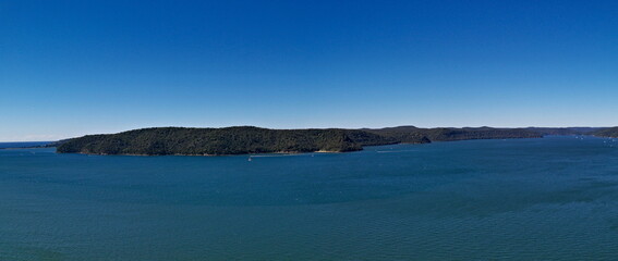 Beautiful panoramic view of a deep blue sea, small Lion island, West Head and Barrenjoey Lighthouse, Warrah Lookout, Brisbane Water National Park, New South Wales, Australia
