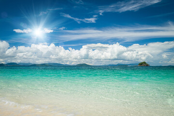 Sandy beaches and azure water of the Adaman Sea against a blue sky with beautiful clouds.