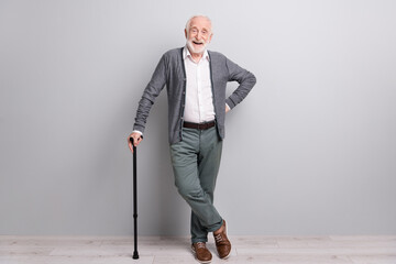 Full size photo of hooray old man stand laugh with wand wear dark sweater trousers isolated on grey wall