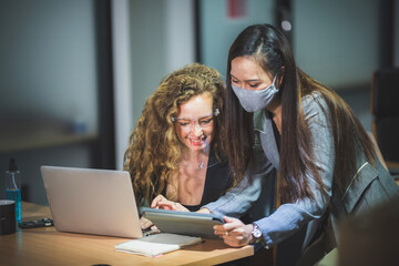 young business person wearing surgical face mask for protection with coronavirus covid-19, working in office with new normal protection lifestyle, social distancing and self-isolated