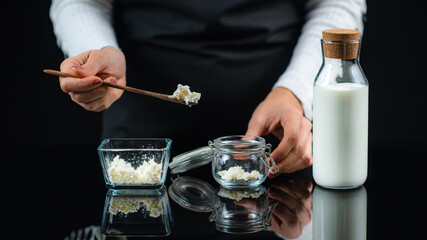 Kefir Grains on a Wooden Spoon Over Jar, Making Kefir at Home.