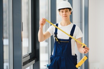 Construction worker installing window in house