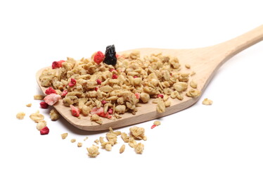 Dried red fruits cereal mix and wooden kitchen spatula, fruity and crunchy muesli with raspberry, strawberry, cherry chunks isolated on white background 