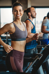 Group of young people running on treadmills in sport gym