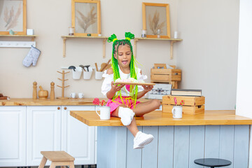 Little beautiful child girl in the kitchen at home happy and funny