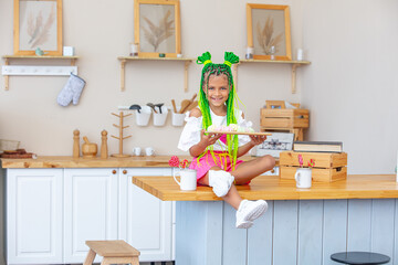 Little beautiful child girl in the kitchen at home happy and funny