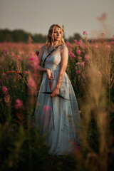 Obraz premium A girl in a dress shoots a bow. Weapon bow. Bow and arrows. Archery. Archery on the field