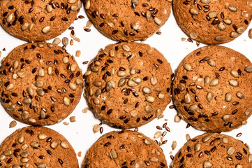 Fresh oatmeal cookies, gingerbread on a light background. Oatmeal gingerbreads sprinkled with sunflower and flax grains close up