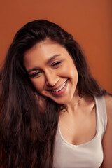 Obraz premium young pretty girl with curly hair posing cheerful on brown background, lifestyle people concept