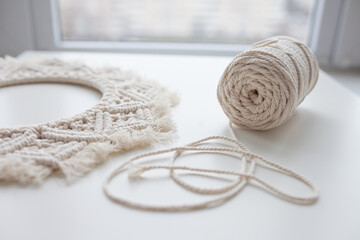 Handmade macrame braiding and cotton threads on white background. Macrame mandala workshop. Boho...